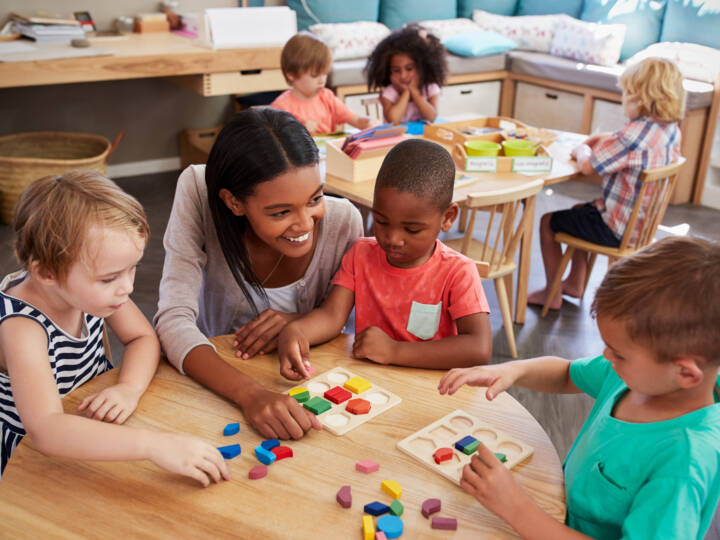 Insegnante e bambini impegnati in un’attività con forme e colori